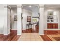 Elegant foyer with tile and wood floors, decorative columns, and built in cabinet at 3829 Eagleflight Ln, Land O Lakes, FL 34639