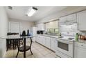 Spacious kitchen featuring white cabinets, granite countertops, and an adjacent dining area at 412 E Columbus Dr, Tampa, FL 33602