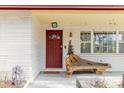 Covered front porch featuring a decorative wooden bench, a unique front door, and brick accents at 549 E Center St, Tarpon Springs, FL 34689