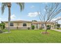 Well-maintained front yard with lush green grass, mature trees, and a charming one story home at 6357 Spanish Main Dr, Apollo Beach, FL 33572