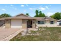 Inviting home with brick accents, an attached garage, and a well-maintained lawn at 6831 Greenwich Ave, New Port Richey, FL 34653