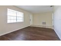 Bright living room featuring wood floors and a large window providing natural light at 7338 Coventry Dr, Port Richey, FL 34668