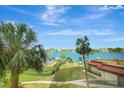 Beautiful view of the water, pool, palm trees, lush landscaping and boat docks from the property at 736 Island Way # 303, Clearwater Beach, FL 33767