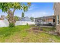 Expansive backyard featuring a lush lawn, privacy fence, and a screened-in patio perfect for outdoor entertaining at 12110 75Th St, Largo, FL 33773