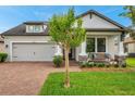 Inviting curb appeal with brick driveway and a landscaped front yard at 12280 Lyon Pine Ln, Odessa, FL 33556