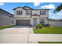 Two-story home with manicured lawn, gray shutters, and a two-car garage at 13227 Great Plains Dr, Riverview, FL 33579