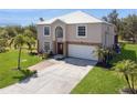 Charming two-story home with a white roof, arched window, decorative stone accents, and meticulously manicured landscaping at 14319 Morristown Ave, Port Charlotte, FL 33981