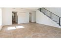 Open-concept living room boasts tile floors and a modern staircase with black metal railings at 14319 Morristown Ave, Port Charlotte, FL 33981