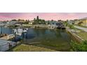 Waterfront view featuring a dock with boats and lush greenery, enhancing the property's appeal at 15621 Bertram Dr, Hudson, FL 34667