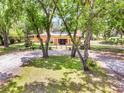 Charming home with mature trees, a landscaped yard, and a welcoming front entrance at 18826 Huckavalle Rd, Odessa, FL 33556