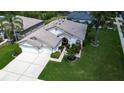 Expansive aerial shot of a well-maintained single-story home with lush green lawn, a two-car garage and mature landscaping at 1920 Folkstone Pl, Wesley Chapel, FL 33543