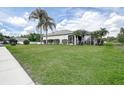 Lush backyard featuring well-maintained green lawn, palm trees and a screened patio, perfect for outdoor relaxation at 1920 Folkstone Pl, Wesley Chapel, FL 33543