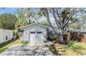 Charming single-story home with a well-manicured lawn, mature tree, and a one-car garage at 201 11Th S Ave, Safety Harbor, FL 34695