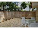 Tiled patio area with outdoor seating, surrounded by a wooden fence at 2725 14Th Ct, Palm Harbor, FL 34684