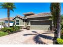 Attractive single-story home featuring a tile roof, manicured landscaping, and a brick paver driveway at 2855 Oriole Dr, Sarasota, FL 34243