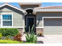 Inviting front entryway with a dark-stained door, stone accents, and manicured landscaping at 2855 Oriole Dr, Sarasota, FL 34243