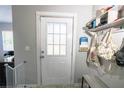 Cozy entryway featuring a white door with glass panes, a storage bench, and decorative wall hooks at 4610 Courtland St, Tampa, FL 33610