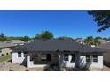 The rear of the house has a patio area, perfect for outdoor entertaining, with several windows and a modern roof at 5051 Gevalia Dr, Brooksville, FL 34604