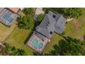Overhead view of backyard with screened pool, lush lawn, and mature trees at 5913 Flatwoods Manor Cir, Lithia, FL 33547