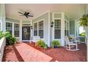 Inviting front porch with brick floor, a ceiling fan, and comfortable seating at 5913 Flatwoods Manor Cir, Lithia, FL 33547