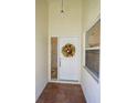 Welcoming front entrance with a decorative floral wreath on a white door and tiled flooring at 6208 Country Club Way, Sarasota, FL 34243