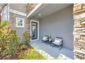 Inviting front porch with cozy seating, stone accents, and lush landscaping, creating a relaxing entrance at 6518 Salt Creek Ave, Apollo Beach, FL 33572