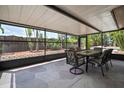 Screened patio with dining table, chairs, and textured concrete flooring overlooking the backyard at 7020 Oakview Cir, Tampa, FL 33634