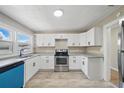 Bright kitchen featuring white cabinets, stainless steel appliances, and modern countertops at 8215 N 12Th St, Tampa, FL 33604