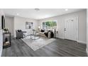 Bright living room with modern decor, hardwood floors, and a large window at 8409 Lantana Dr, Seminole, FL 33777