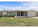 Inviting single-story home with stone accents, a screened porch, and well-maintained lawn at 3748 Redwood Dr, Holiday, FL 34691