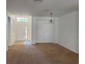 Spacious living room with carpet flooring, white walls, and natural light coming from the front door at 11318 Laurel Brook Ct, Riverview, FL 33569