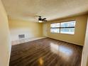 Bright living room featuring hardwood floors, ceiling fan and abundant natural light at 12054 145Th St, Largo, FL 33774