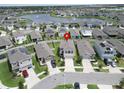 Aerial view of a home in a vibrant neighborhood with a scenic lake and lush green spaces nearby at 17006 Wave Tressle Pl, Wimauma, FL 33598