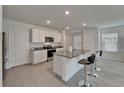 Bright kitchen features an island with bar seating, stainless steel appliances, and granite countertops at 17006 Wave Tressle Pl, Wimauma, FL 33598