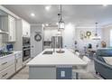 A kitchen is equipped with stainless steel appliances, a large island, and sleek white cabinets at 17212 Balance Cv, Land O Lakes, FL 34638