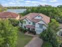 Overhead view of home featuring tile roof, mature landscaping, and view of community and lake at 1804 Bella Casa Ct, Tampa, FL 33618