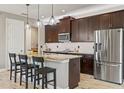 Bright kitchen features granite countertops, a stainless steel refrigerator, and dark wood cabinetry at 18872 Noble Caspian Dr, Lutz, FL 33558