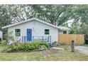 Charming single story home featuring a blue door and porch, complemented by a lush, green yard at 1920 30Th E Ave, Bradenton, FL 34208