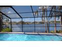 Screened-in pool with stunning lake view, creating a serene and private backyard oasis at 23059 Geneva Rd, Land O Lakes, FL 34639
