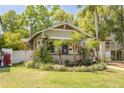 Cute home with a manicured lawn, flower beds, and mature trees, creating a charming curb appeal at 300 16Th N Ave, St Petersburg, FL 33704