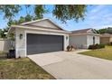 A charming single-story home featuring a well-maintained lawn, gray exterior, and a dark gray garage door at 3011 49Th S Ter, St Petersburg, FL 33712