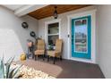 Inviting front porch with a light-wood ceiling, seating area, stone ground cover, and a stylish blue door at 3011 49Th S Ter, St Petersburg, FL 33712
