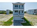 Charming three-story beach house with covered balconies and landscaped front yard, perfect for coastal living at 4215 Saltwater Pearl Way, Cortez, FL 34215