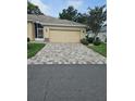 Paver driveway leading to the front of a one story home and two-car garage at 607 Manchester Woods Dr # 84, Sun City Center, FL 33573