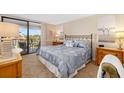 Cozy bedroom featuring a large bed with balcony access, and water view at 6357 Bahia Del Mar Blvd # 403, St Petersburg, FL 33715