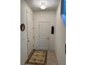 Bright entryway featuring tile floors, white walls, and a decorative rug at 8273 Artisan Way, Seminole, FL 33777