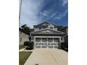 Two-story home with a gray exterior, well-maintained lawn, and a large two-car garage at 8273 Artisan Way, Seminole, FL 33777