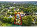 An aerial view displays the property along the water, surrounded by verdant trees and neighborhood homes at 8615 Jackson Springs Rd, Tampa, FL 33615