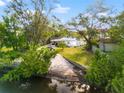 This is an exterior view of a single-story home with a large yard leading to a waterfront area at 8615 Jackson Springs Rd, Tampa, FL 33615