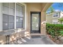 Cozy front porch with a black front door, window, and a small table at 8901 Casablanca Way, Tampa, FL 33626